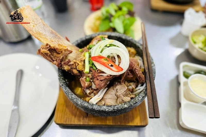 “Bun bo” (beef noodle soup) is kept hot in a stone pot