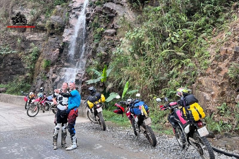 Group of bikers stopping by a waterfall in Ha Giang