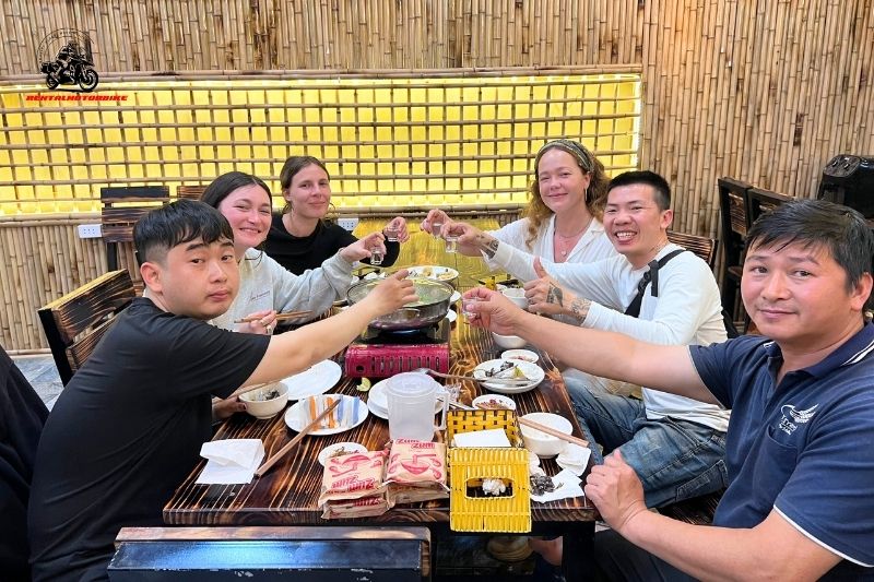 Group of Ha Giang Loop riders enjoying hotpot dinner together