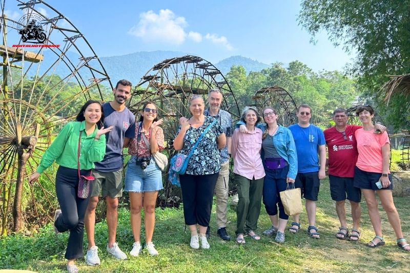Group photo with bamboo water wheels in rural Vietnam