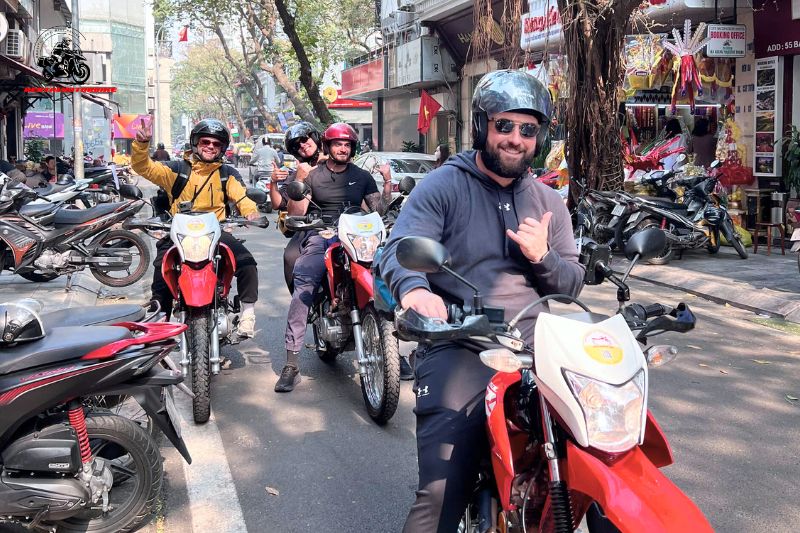 Tourists on motorbikes in bustling Hanoi street