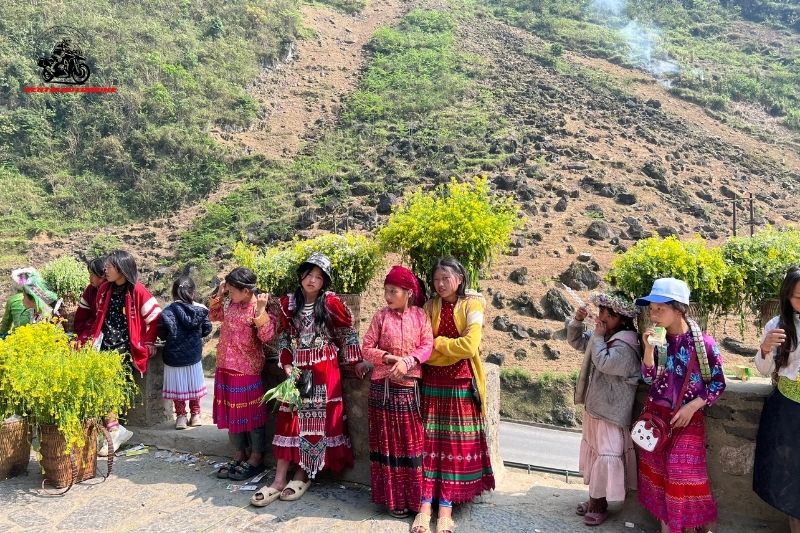 A group of local children in colorful, traditional attire on a roadside