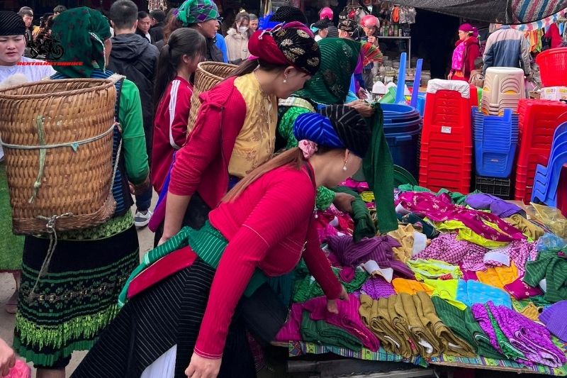 Women browsing fabrics at a mountain market