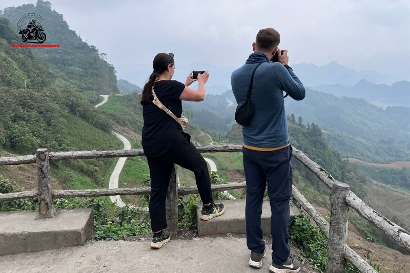 Tourists taking photos at a mountain viewpoint