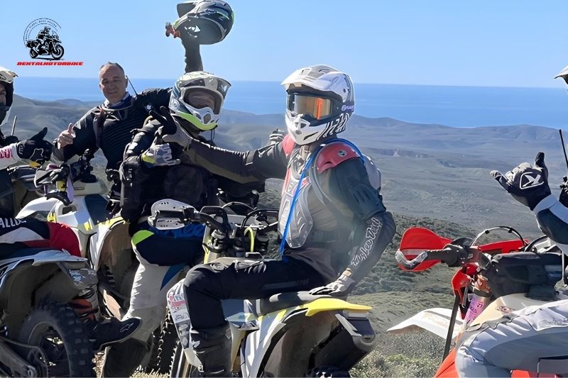 Off-road bikers celebrating at a scenic mountain viewpoint