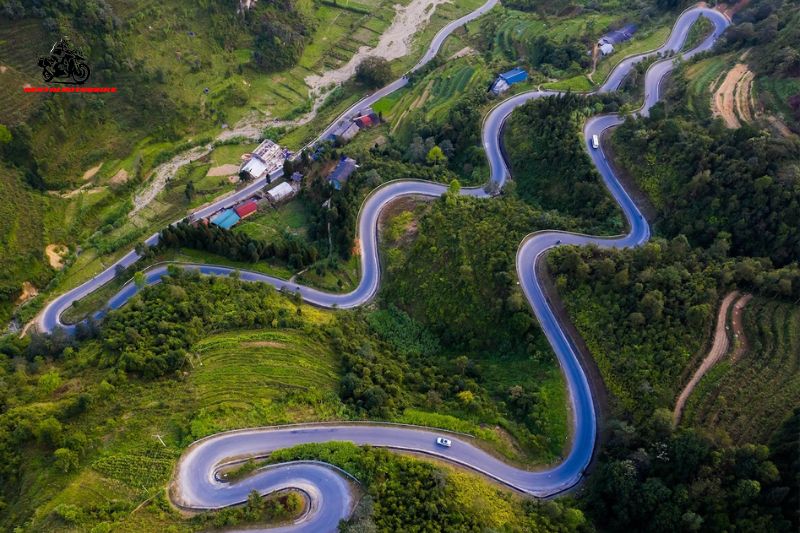 Drone shot of winding mountain road through green hills