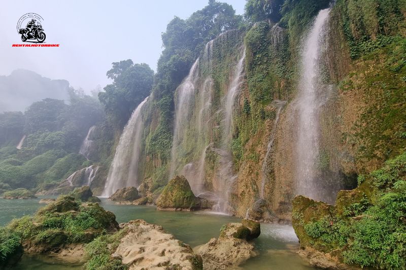 Tall, lush waterfall cascading into turquoise river