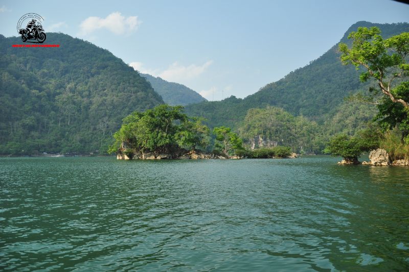 Calm lake surrounded by forested mountains and rocky islands