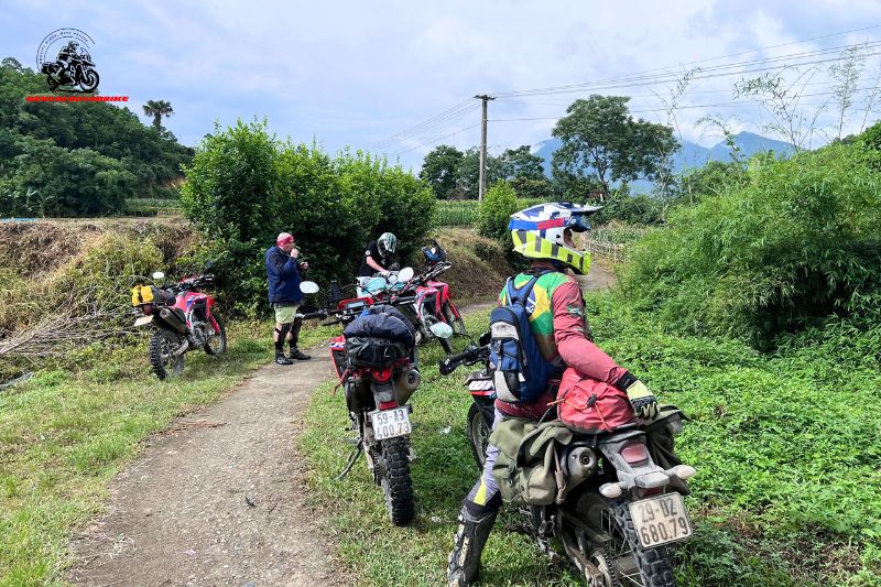 Riders on dirt bikes resting on a forest trail