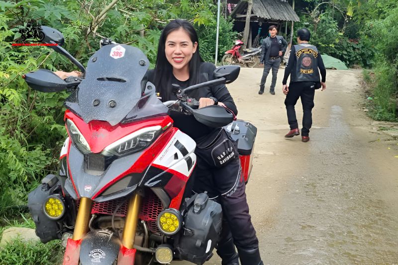 Woman with touring motorbike, riders in the background