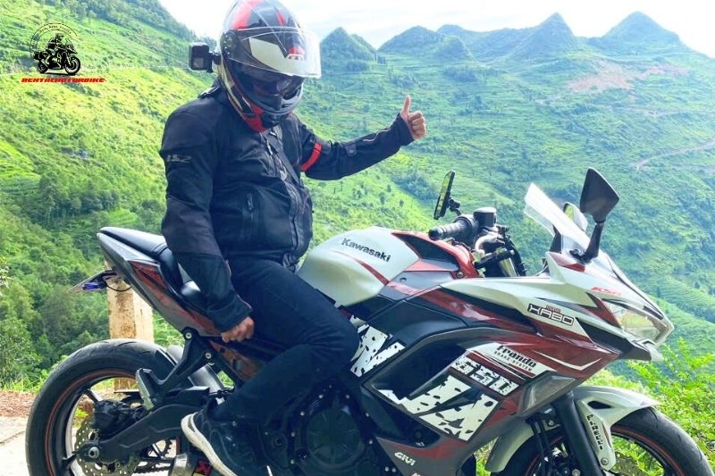 Biker on a Kawasaki sportbike with green mountains in background