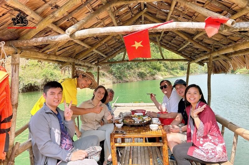 Group enjoying traditional lunch on a bamboo raft on the river